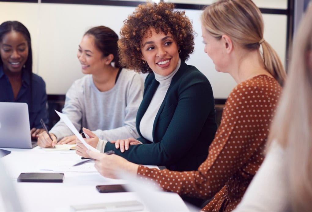 Group Of Businesswomen Collaborating In Creative Meeting Around Table In Modern Office